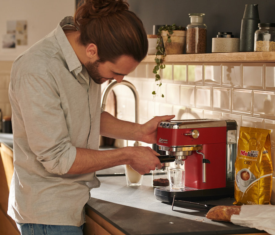 Adam kırmızı »Lapressa« Portafiltre Makinesi ile kahve hazırlıyor.