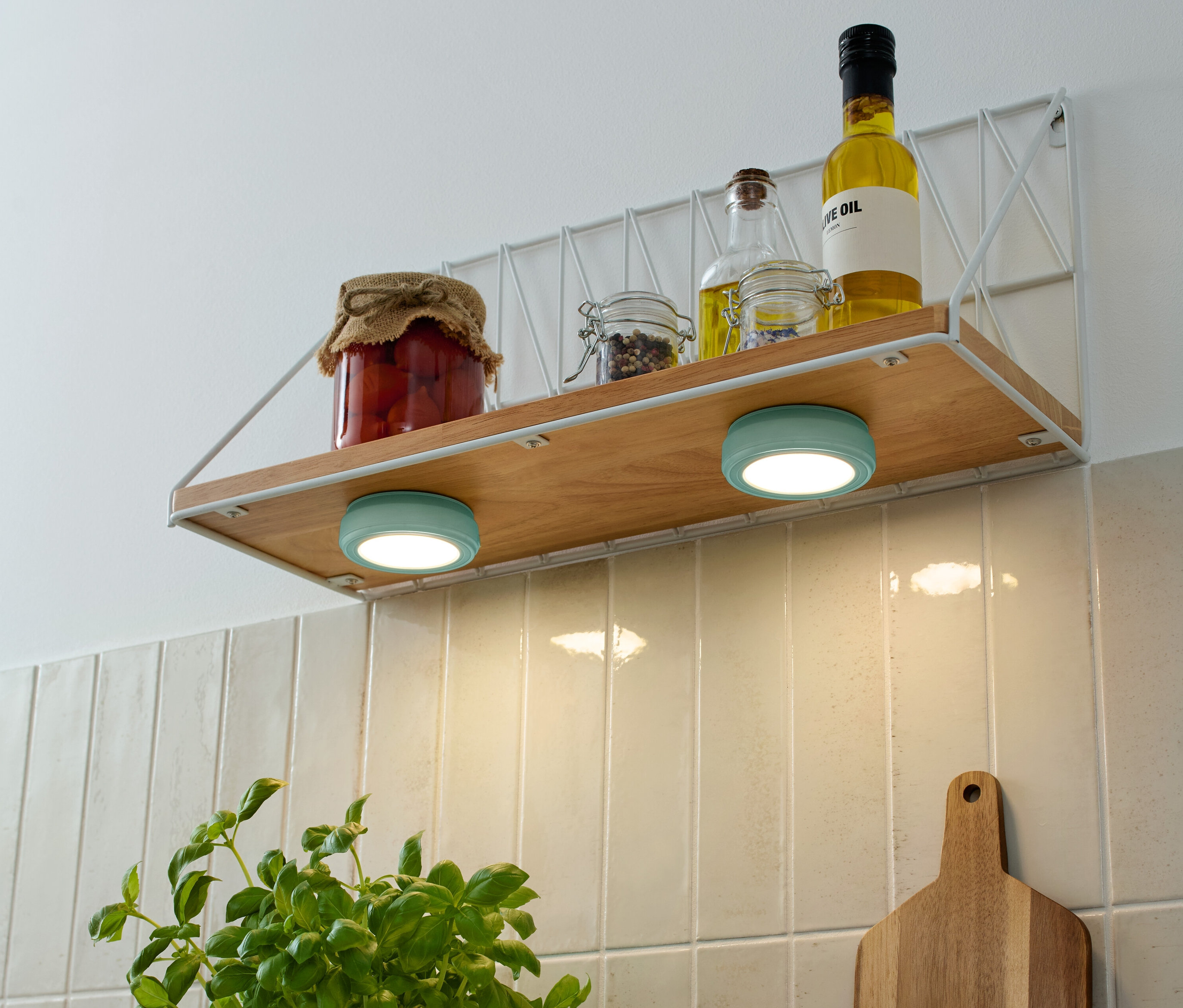 Bir rafta saklama kavanozları ve yağ şişeleri ve altında iki turkuaz renkli 2 LED-Multifunktionsleuchten bulunmaktadır.