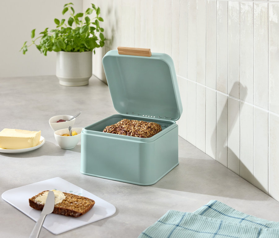 Açık, açık mavi ekmek kutusu, yanında tereyağı, reçel, bıçak ve üzerine sürülmüş ekmek.