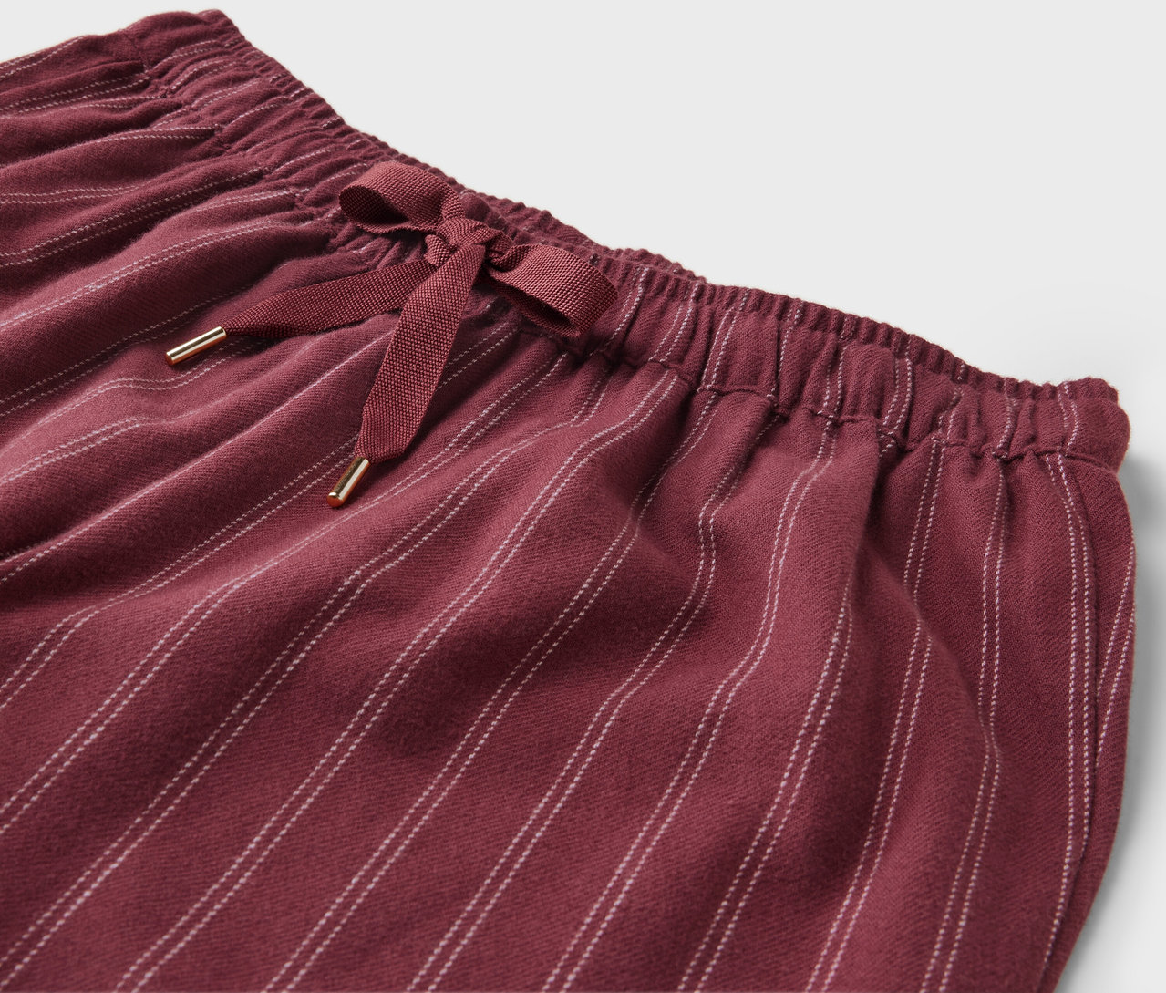 Bordo rengi, çizgili bir pantolonun belinde kurdele detayı.