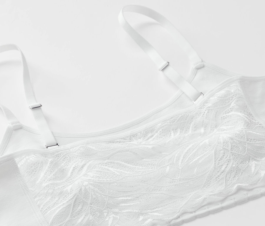 Beyaz dantelli dikişsiz bir büstiyerin yakın çekimi.