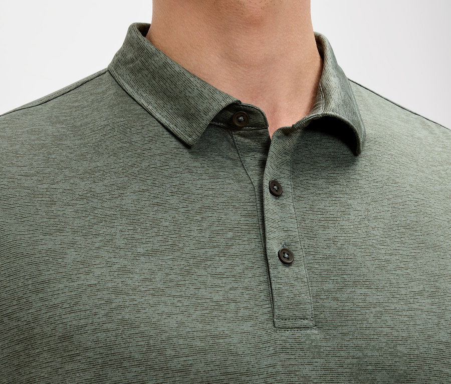 Yeşil polo tişört giyen bir adamın yakın çekimi.