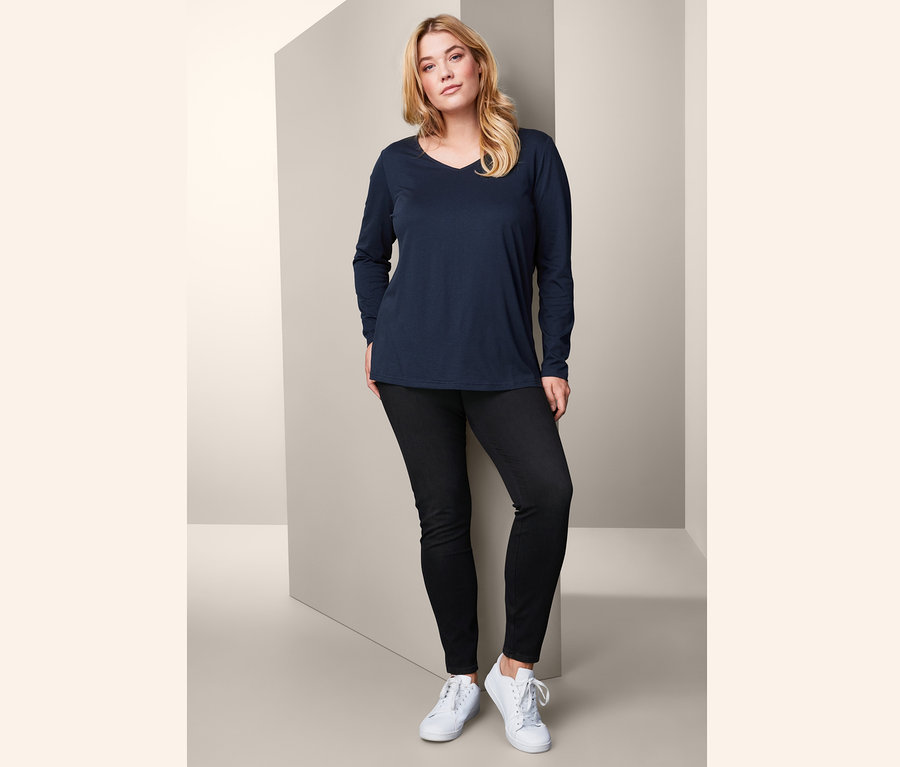 Kadın Uzun Kollu Tişört ve Jeggings ile poz veriyor.