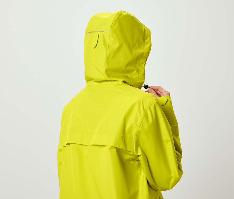 Limon sarısı kapüşonlu bir mont giyen bir kişi arkadan büzgüyü ayarlıyor.