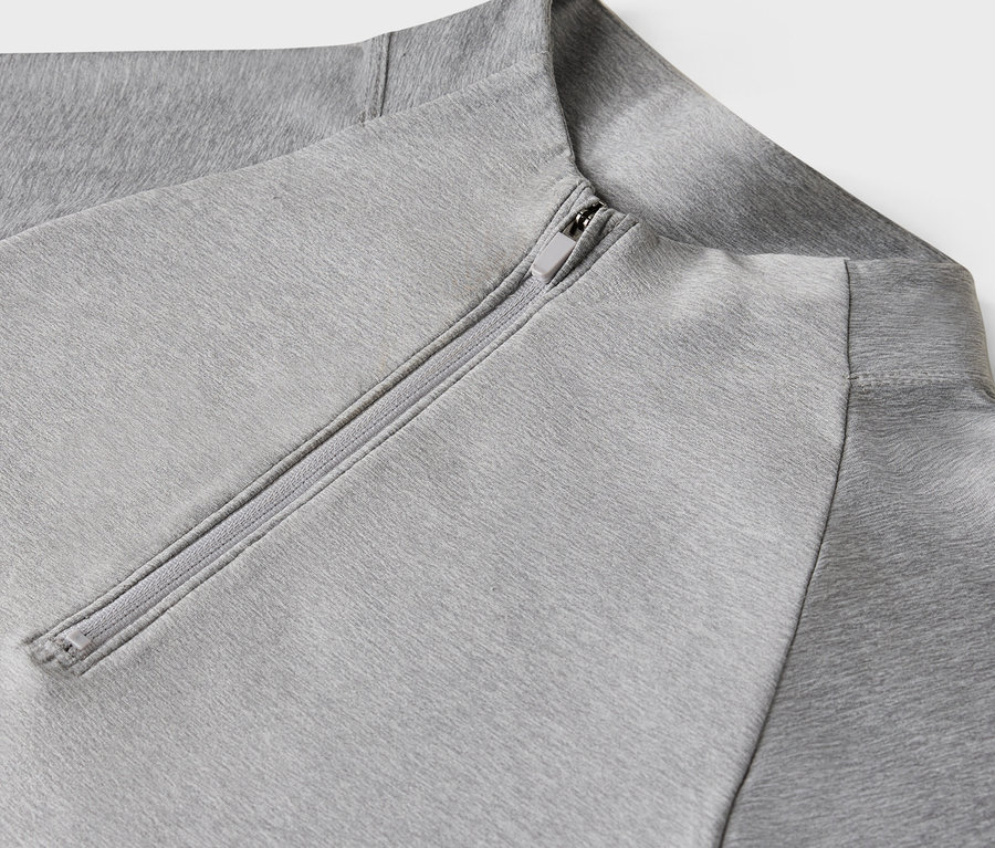 Açık gri renkli, fermuarlı bir sweatshirt'ün yakın çekim detayı.