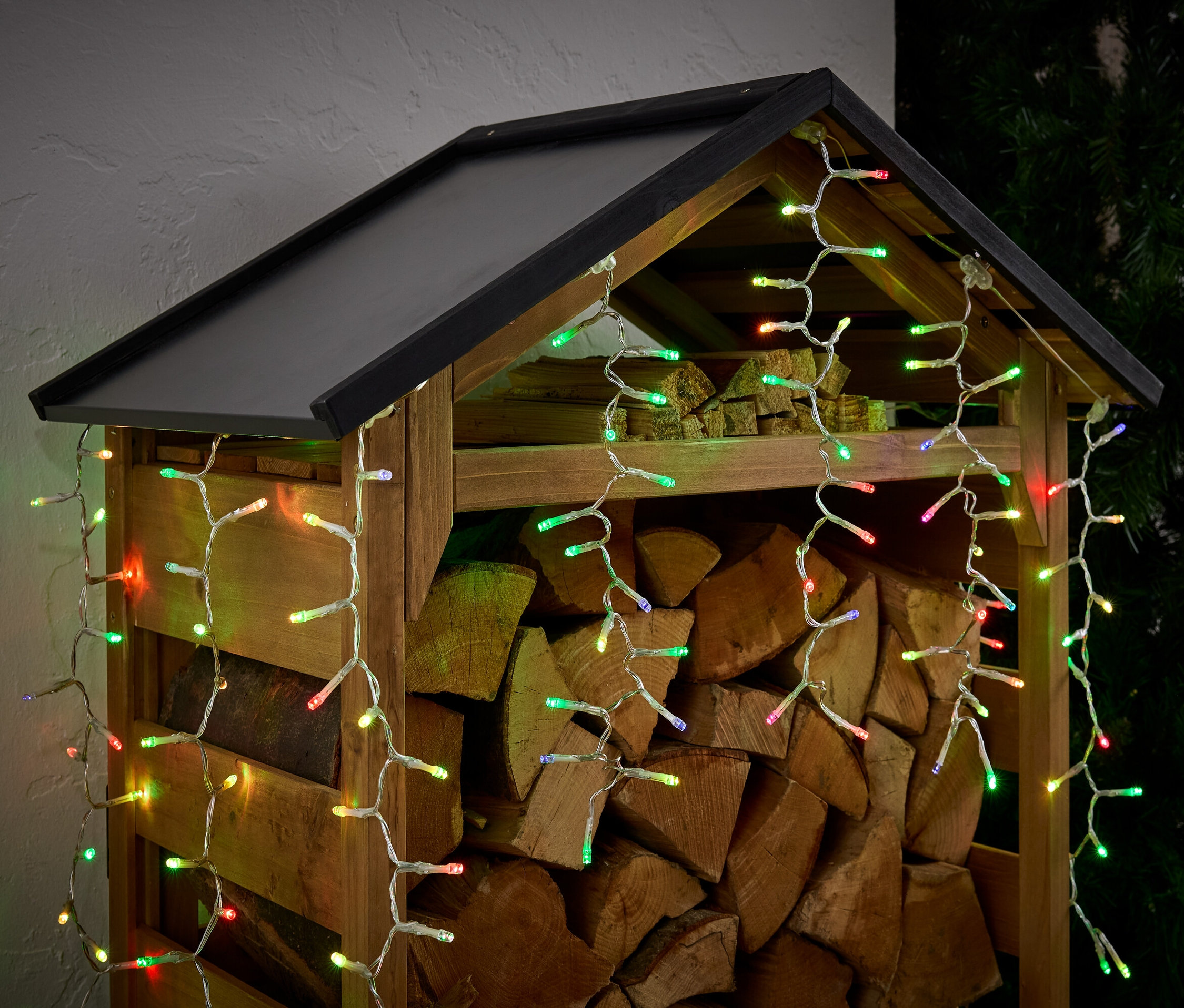 Odunlarla dolu, renkli ışıklarla süslenmiş odunluk.
