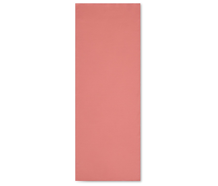 Düz pembe renkli bir yoga matı beyaz bir arka plan üzerinde duruyor.
