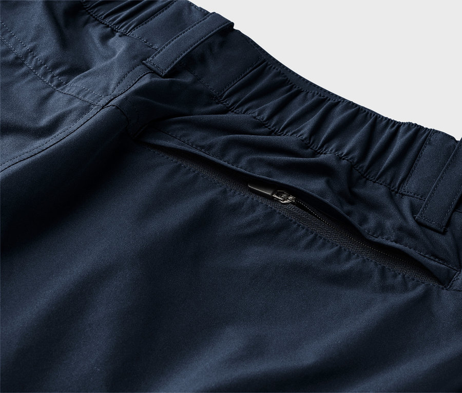 Elastik belli ve fermuarlı cepli lacivert pantolonun yakın çekimi.