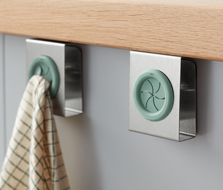 İki adet bulaşık bezi tutucu bir dolaba takılıdır, birinde bir bulaşık bezi asılıdır.