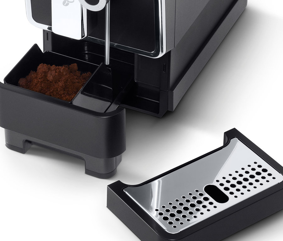 Antrasit rengi »Esperto Pro« Tchibo Tam Otomatik Kahve Makinesinin, çıkarılmış kahve telvesi haznesi ve damlama tepsisi ile yakın çekim detayı.