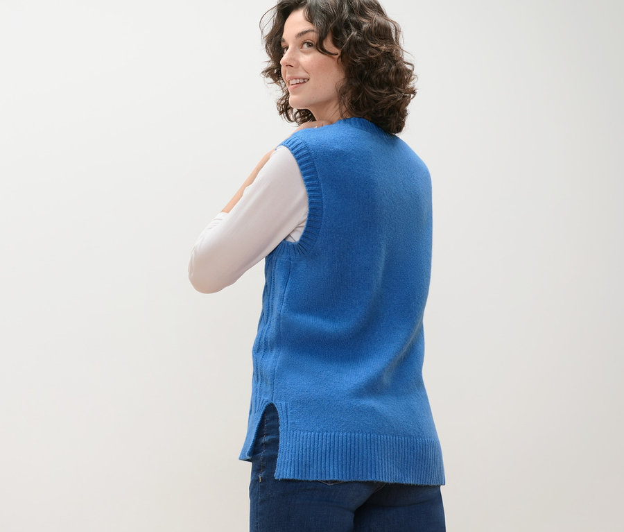 Kadın omzunun üzerinden bakıyor ve Saç Örgüsü Motifli Süveter giyiyor.