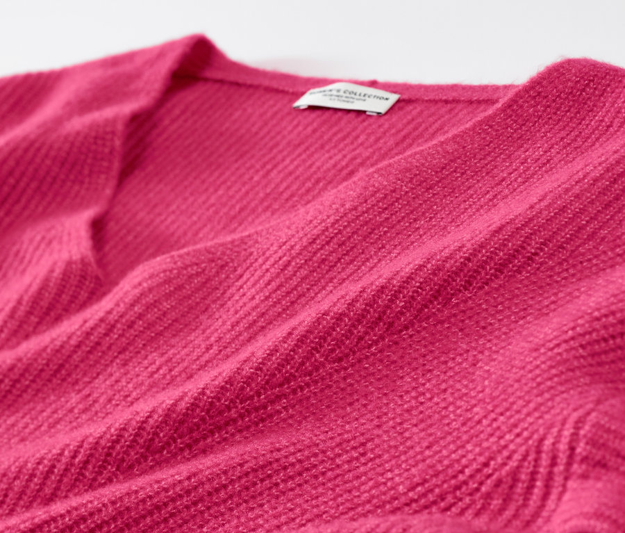 Ahududu rengi, kalın örgülü kazağın yakın çekim detayı.