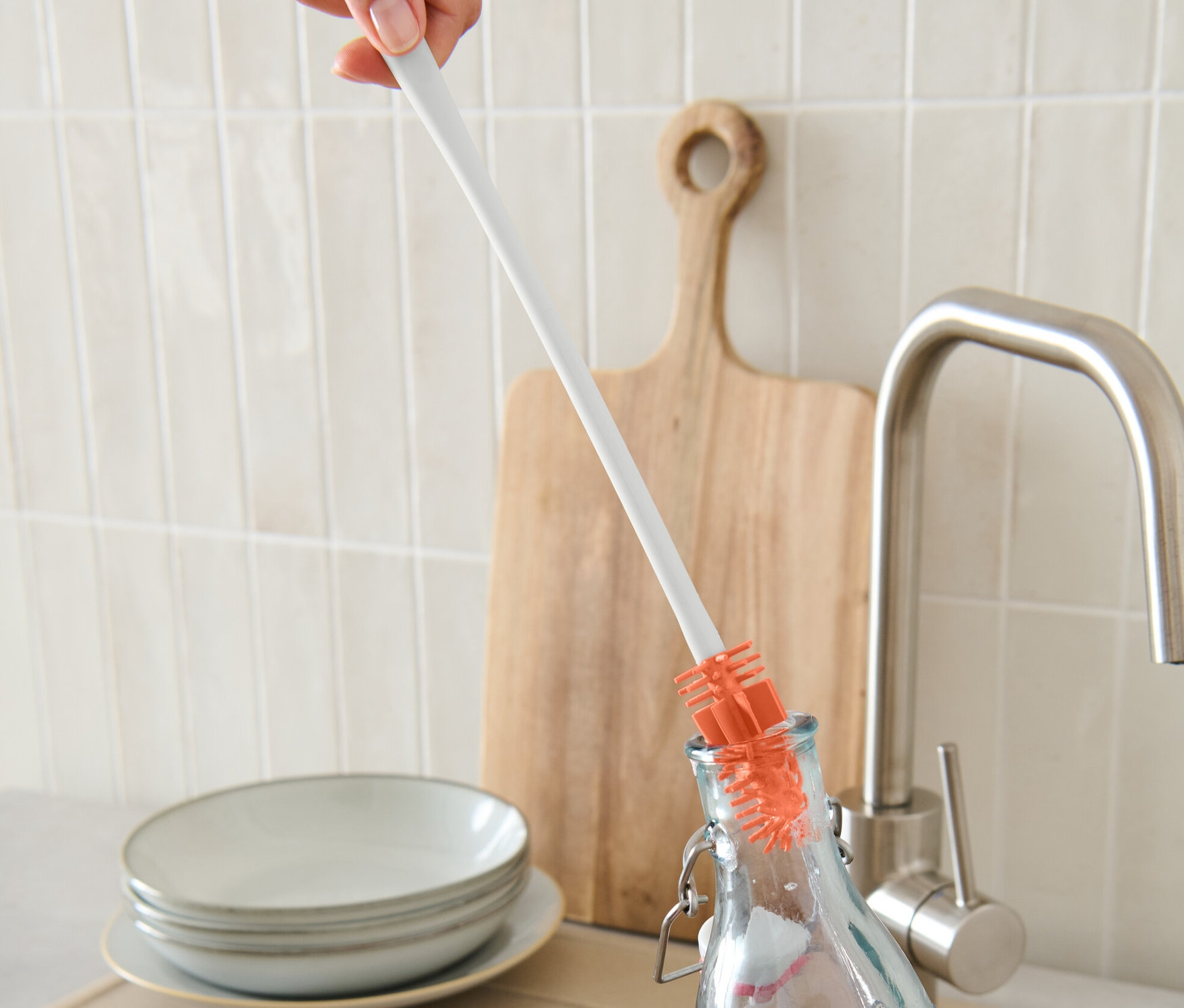 Bir el, bir şişe fırçasıyla şişe temizliyor.