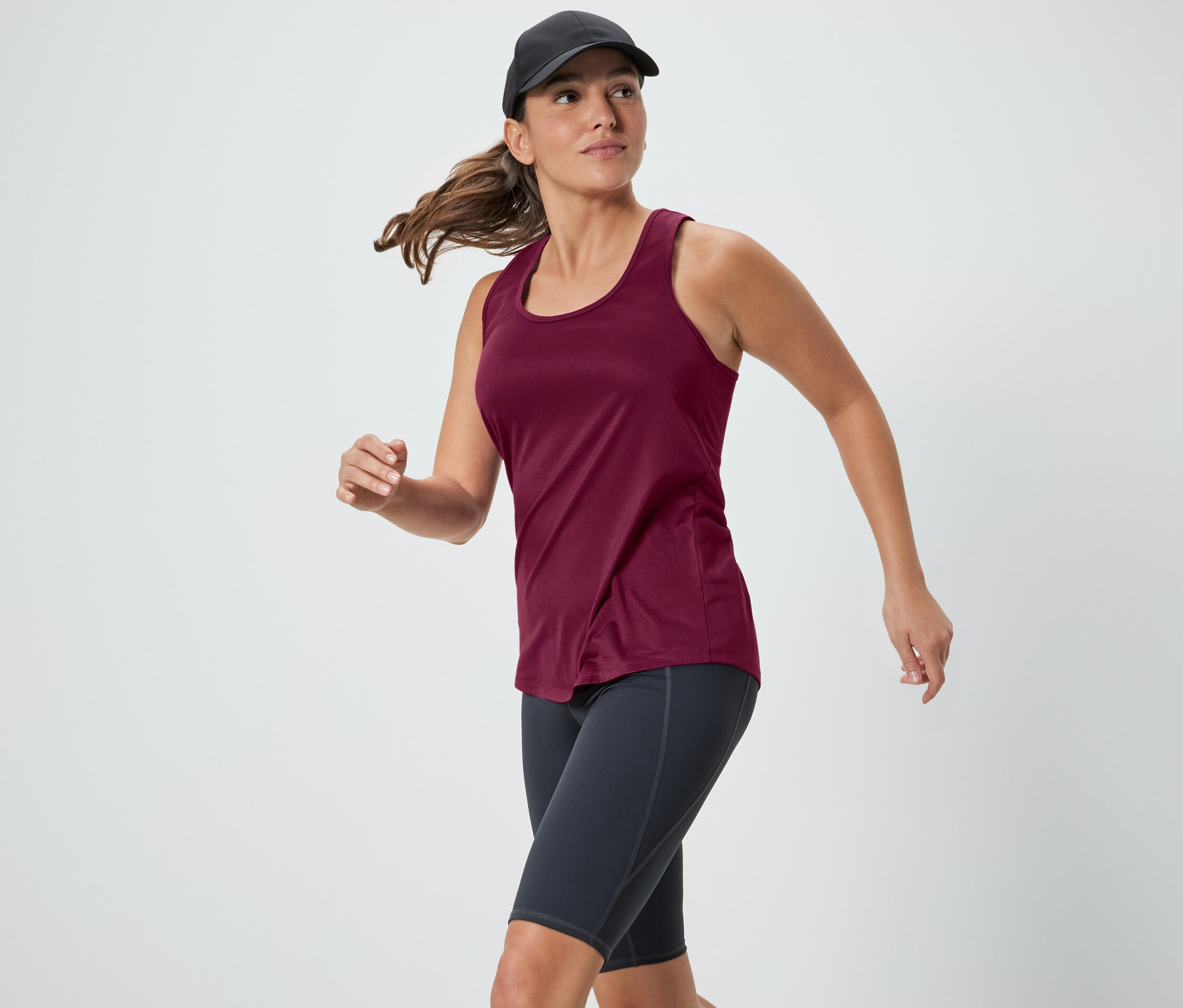 Kadın, iki parçalı bir setten pembe bir fonksiyonel atletle koşuyor.