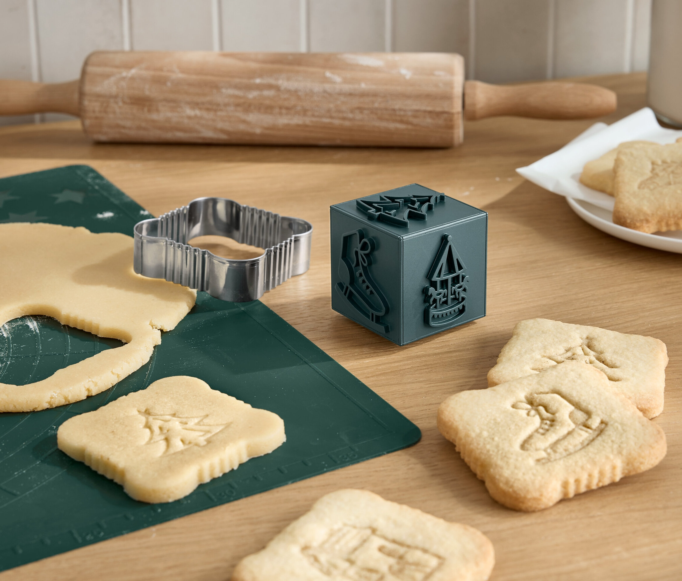 Noel kurabiyeleri, kurabiye kalıbı, oklava ve kurabiye damgası ile kesiliyor.