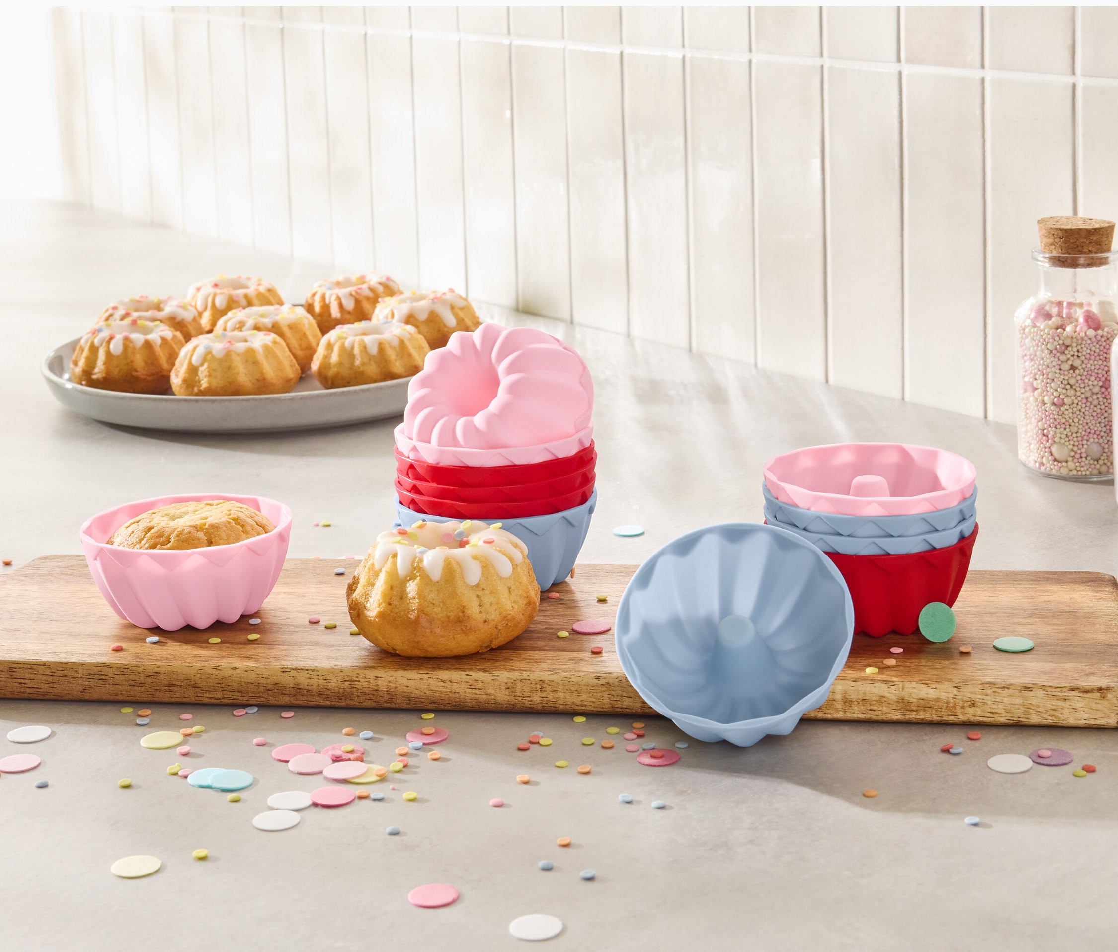 Tabakta mini kekler ve ahşap bir tahta üzerinde 12'li mini kek kalıpları.