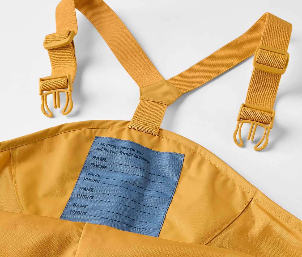 Sarı askıları olan, askılı çocuk yağmurluğunun yakın çekimi.