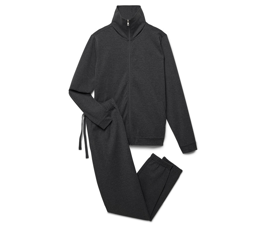 Beyaz bir arka plan üzerinde fermuarlı bir ceket ve pantolon bulunan gri bir eşofman takımı.