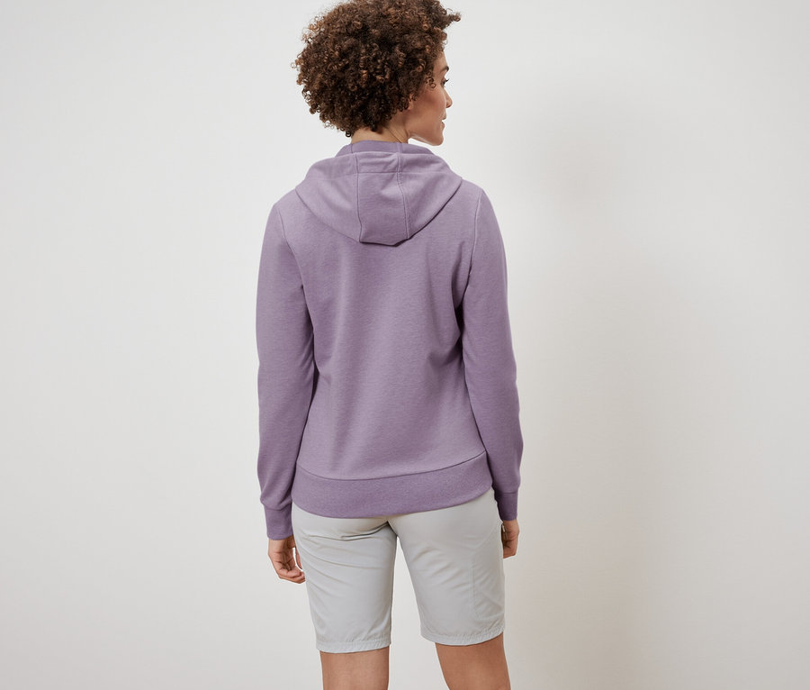 Kıvırcık saçlı bir kadın, sweatshirt ve şort giyiyor, arkadan görünümü.