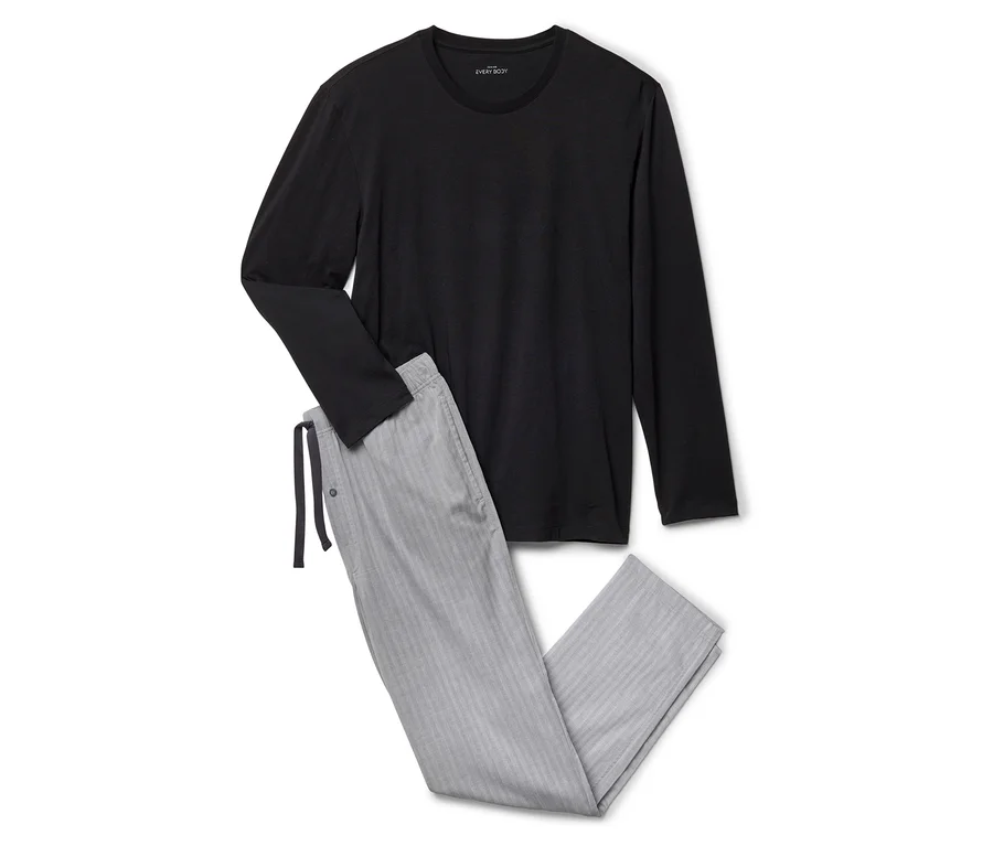 Siyah uzun kollu bir tişört ve gri çizgili bir pijama altı beyaz bir zeminde duruyor.