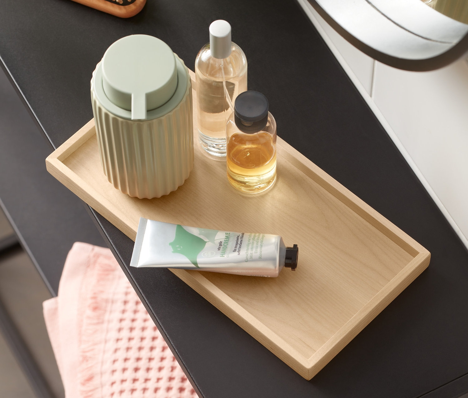 Ahşap tepsili, sabunluklu, şişeli ve havlulu makyaj masası.