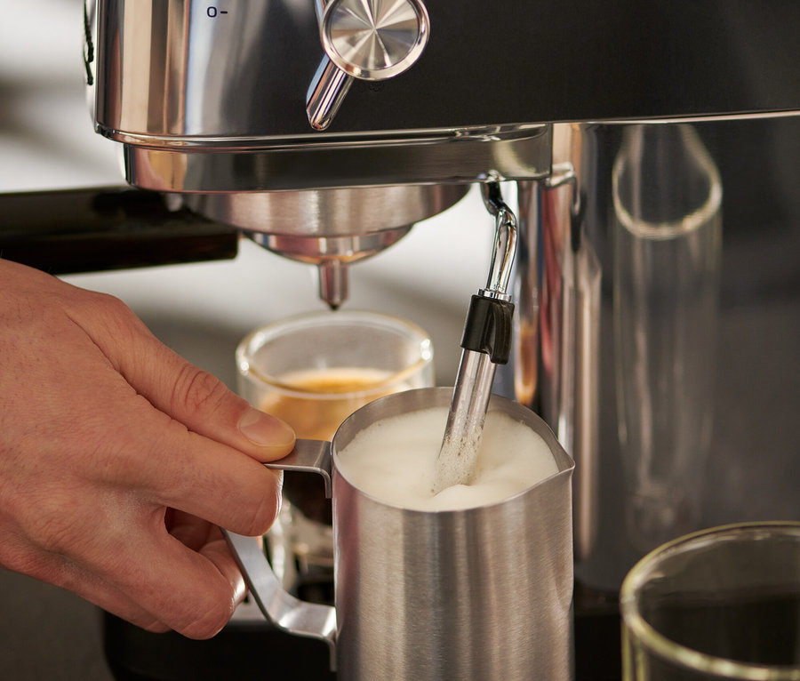 Adam gümüş »Lapressa« Portafiltre Makinesi ve 300 ml Paslanmaz Çelik Sütlük kullanıyor.