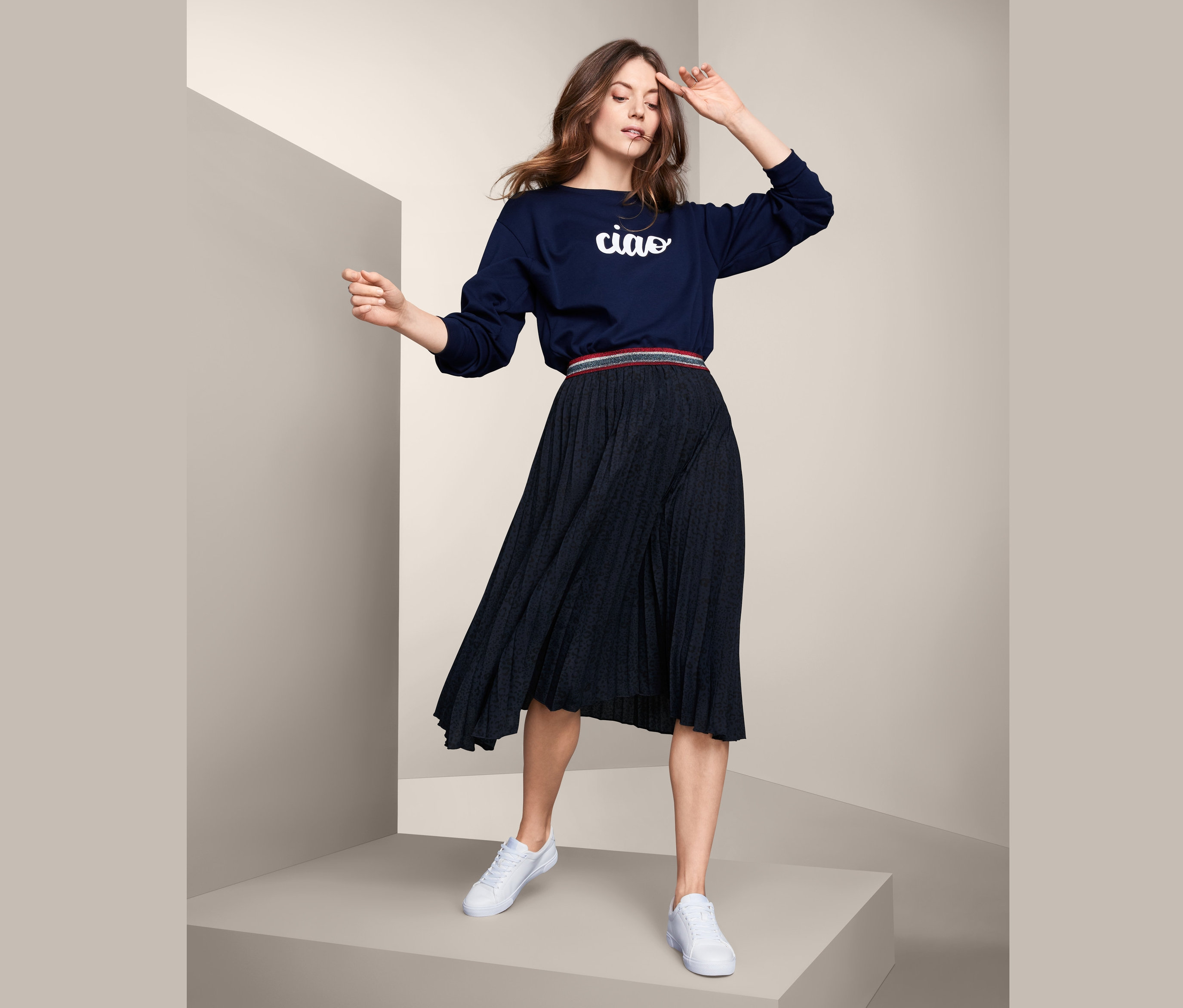 Pileli etekli kadın poz veriyor.