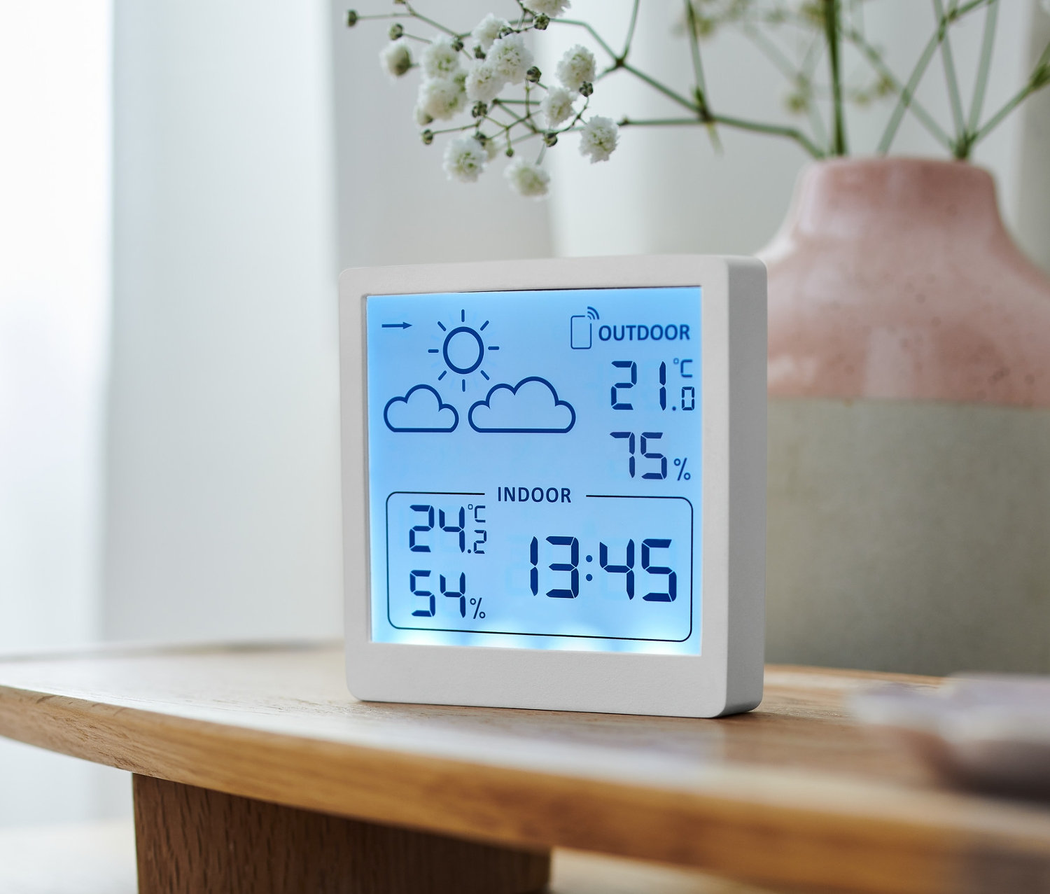 Beyaz bir meteoroloji istasyonu iç ve dış sıcaklığı ve nemi gösteriyor.