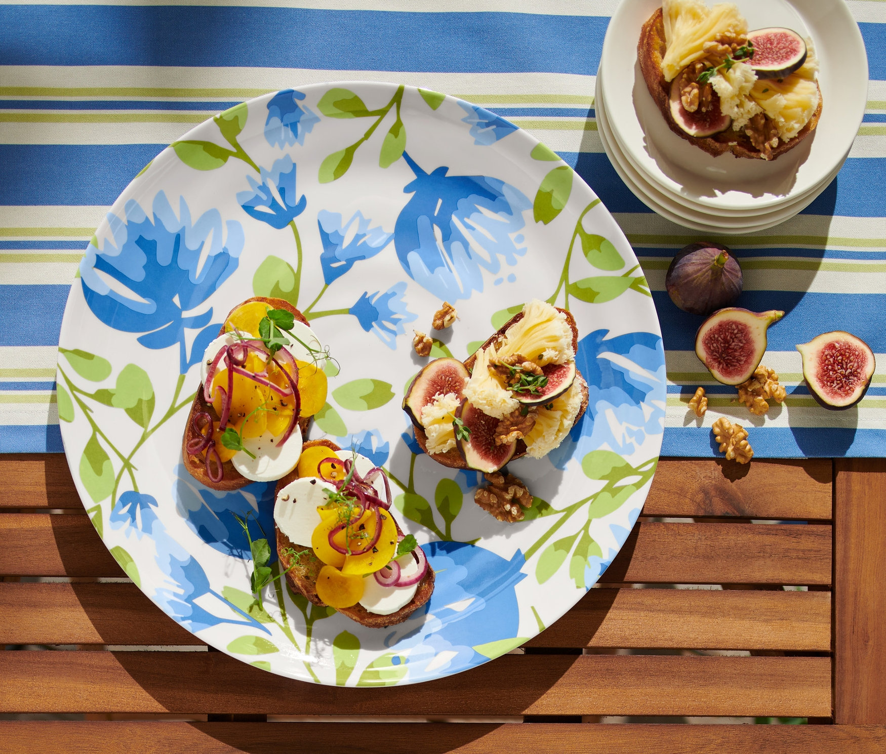 Masanın üzerinde süslü tostlar ve incirlerle dolu bir servis tabağı duruyor