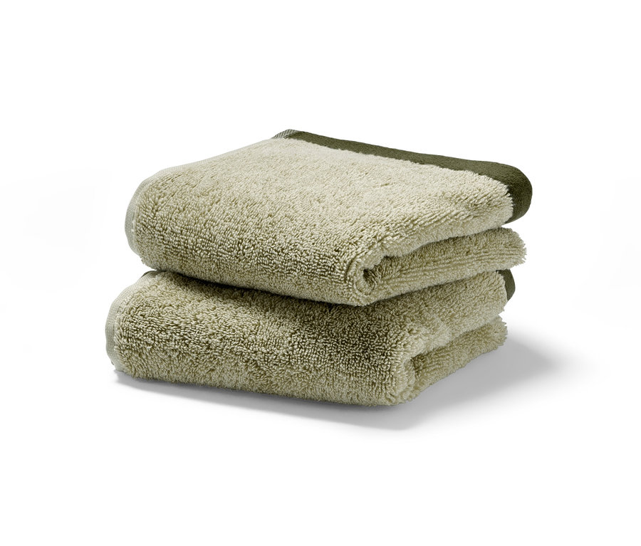 Üst üste istiflenmiş iki adet yüksek kaliteli jakar misafir havlusu.