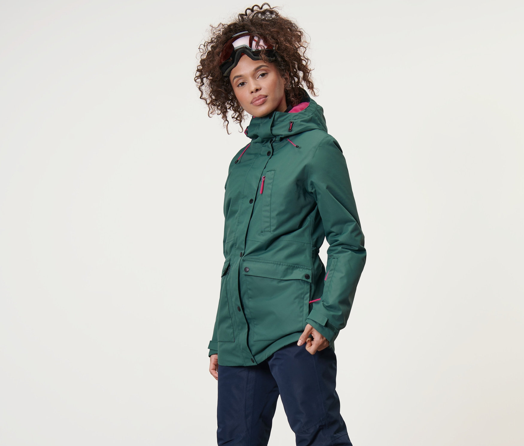 Kadın kayak ve snowboard montu ve kayak pantolonu giyiyor.