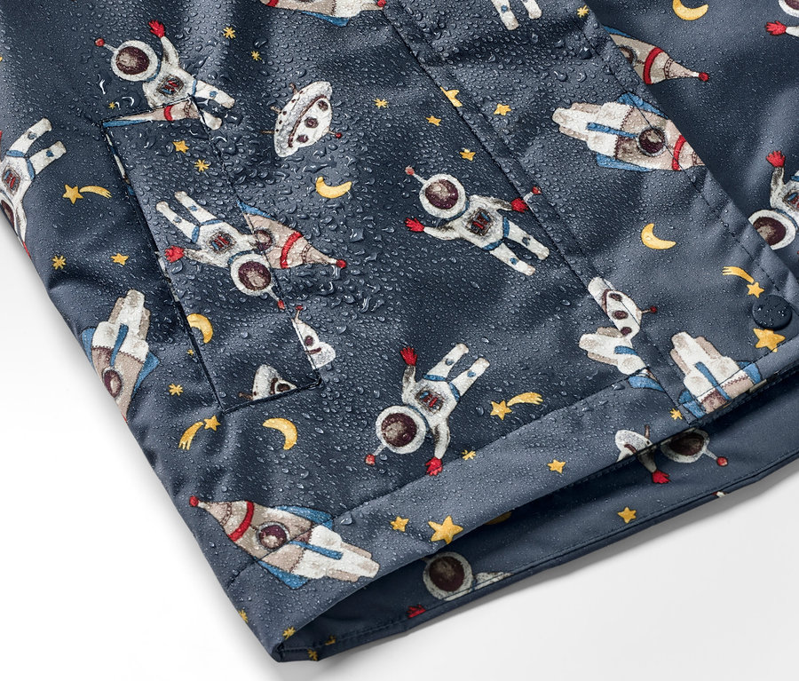 Lacivert çocuk termal yağmurluğun astronot, roket ve yıldız desenli detayı.
