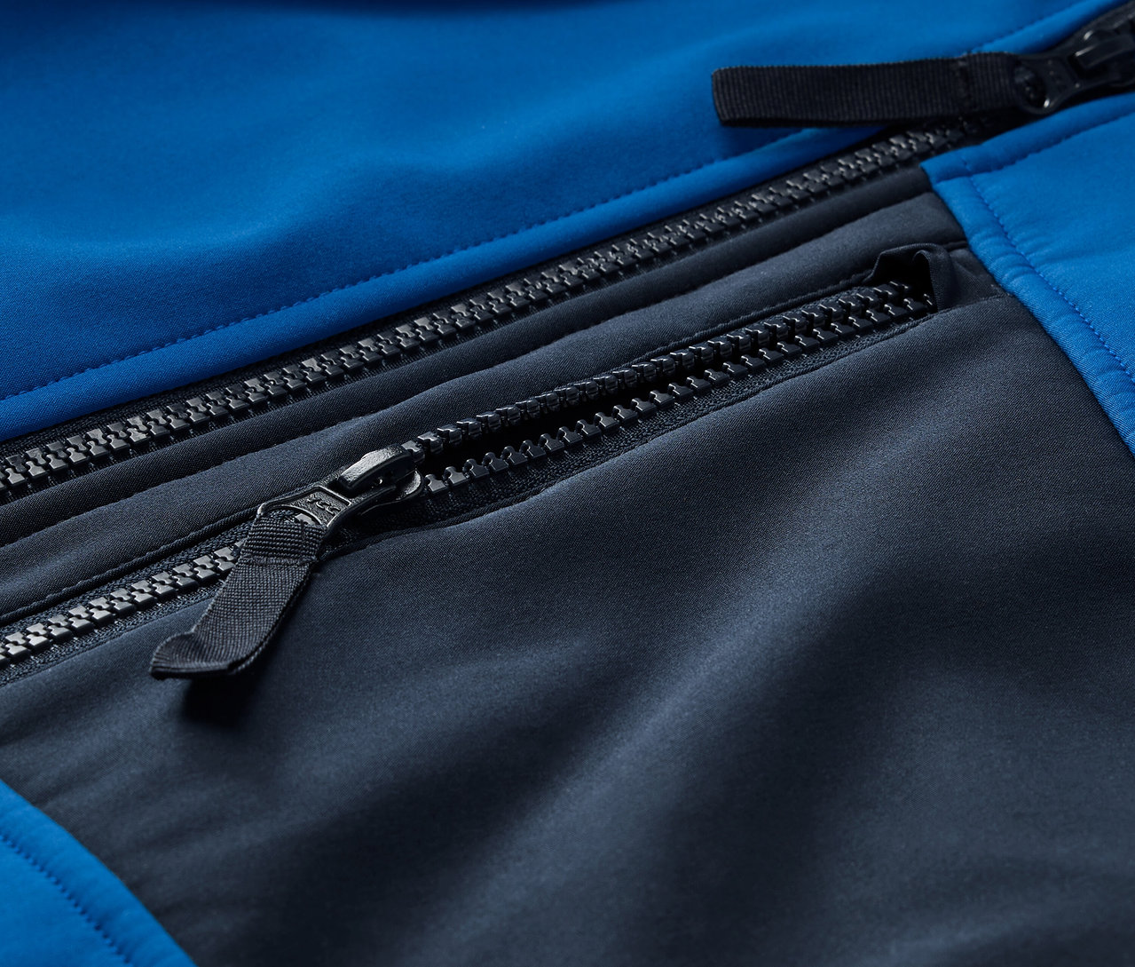 Fermuarlı mavi ve siyah softshell ceket detayı.