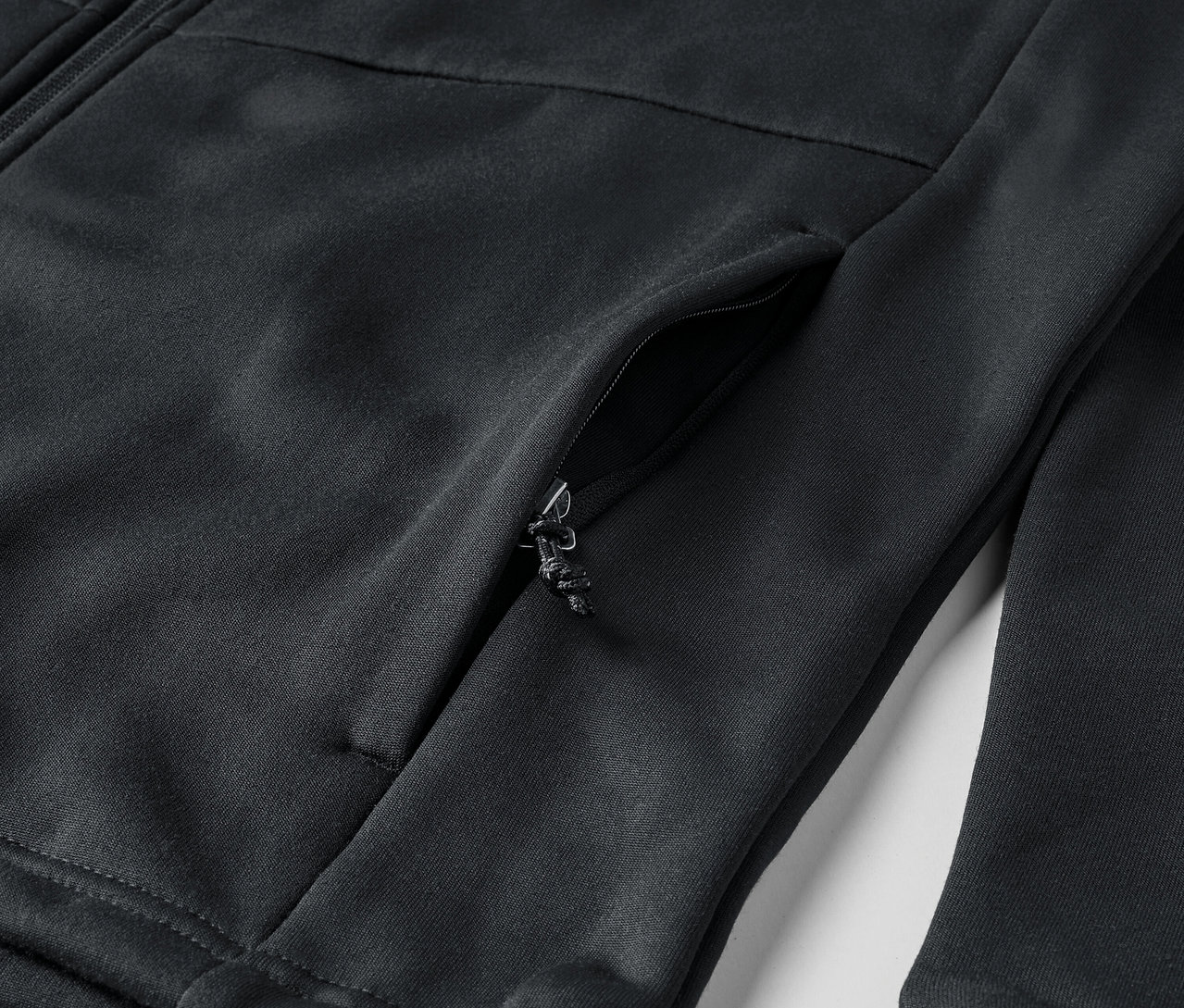 Siyah fermuarlı ve cepli bir sweatshirt'ün yakın çekim detayı.