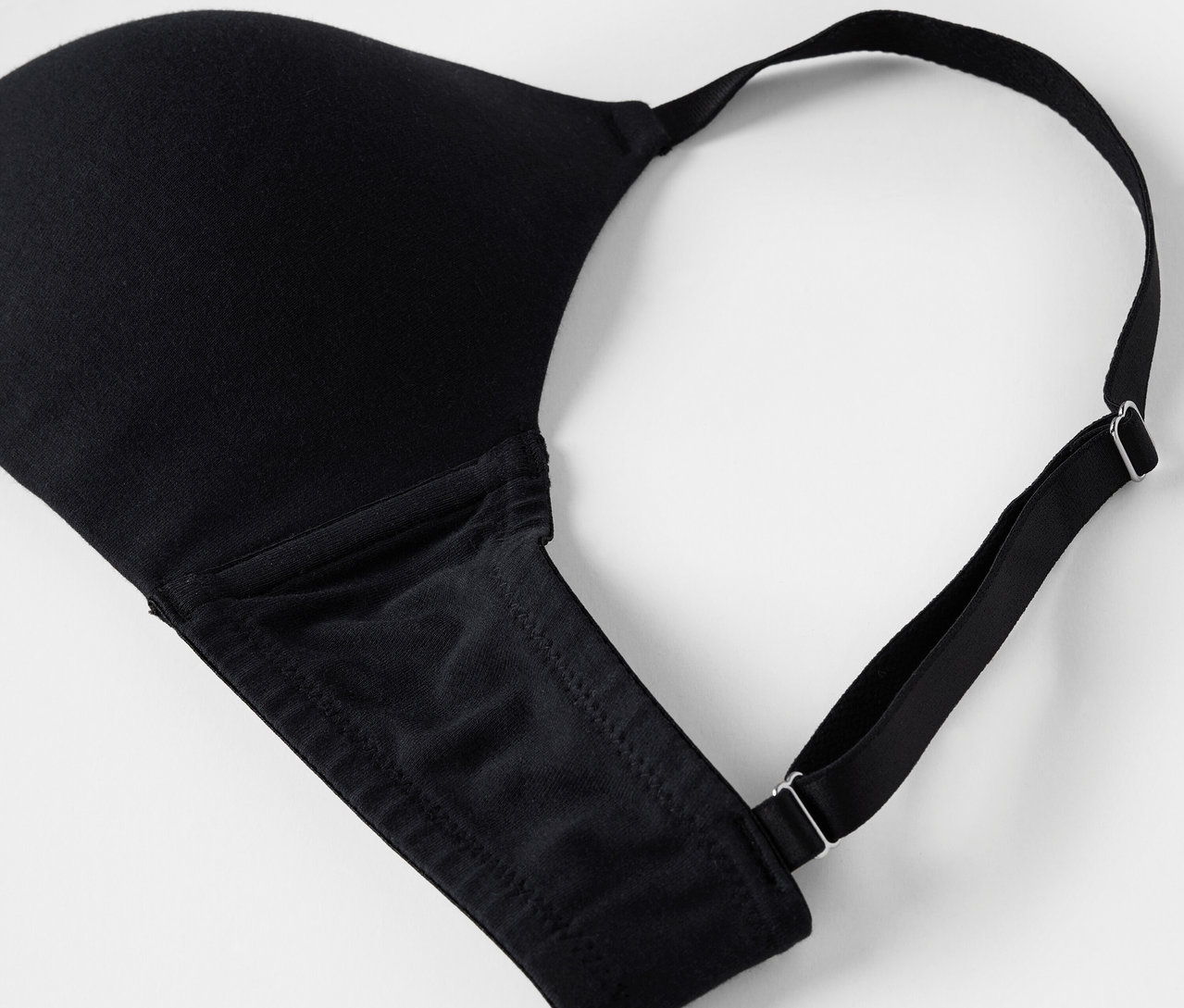 Beyaz bir arka plan üzerinde siyah bir sütyenin detayı.