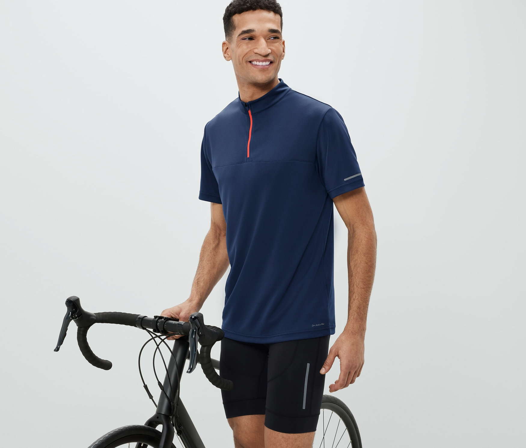 Bisikletin yanındaki adam Bisiklet Forması giyiyor.