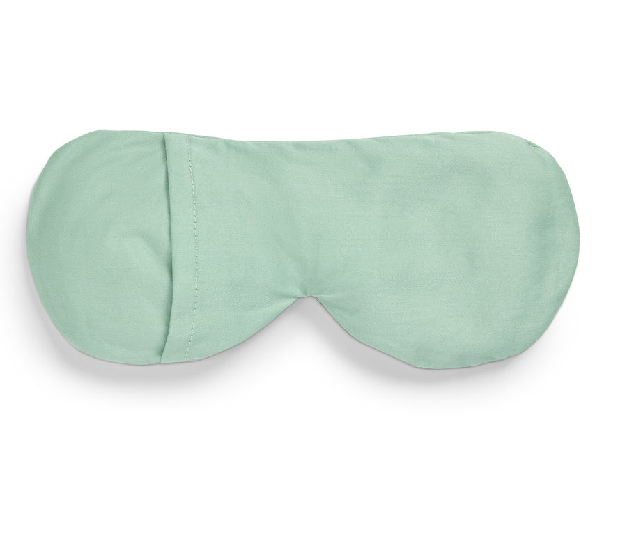 Açık yeşil uyku maskesi beyaz bir arka plan üzerinde duruyor.