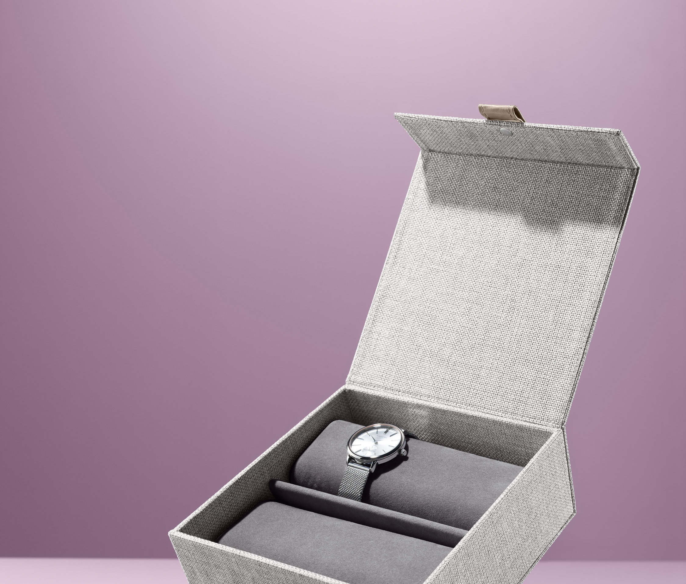 İçinde gümüş bir saat olan açık saat kutusu.