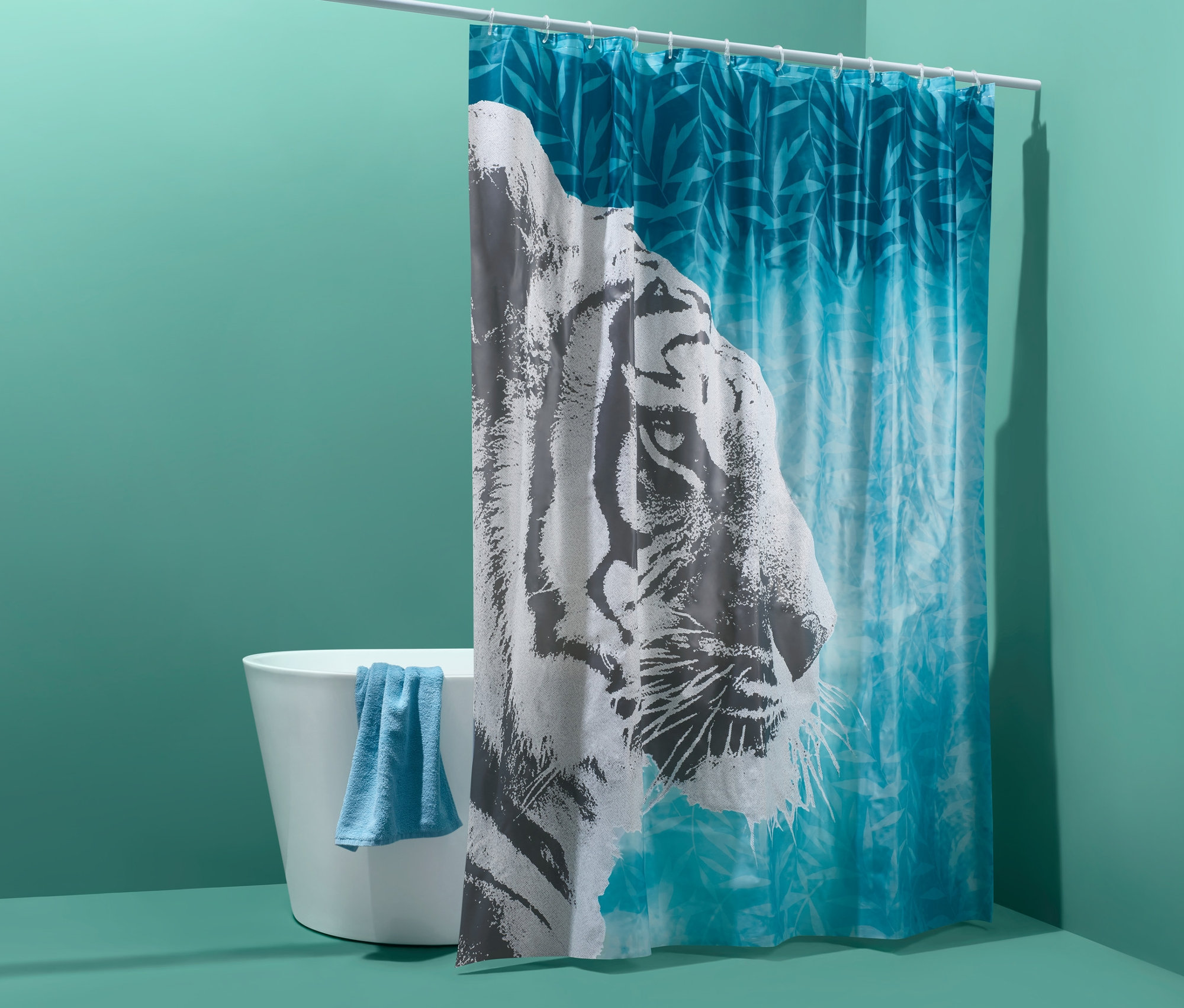 Mavi havlulu küvet ve kaplan desenli duş perdesi.