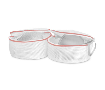 Pembe şeritli iki adet beyaz sütyen yıkama filesi, bir filede gri sütyen var.