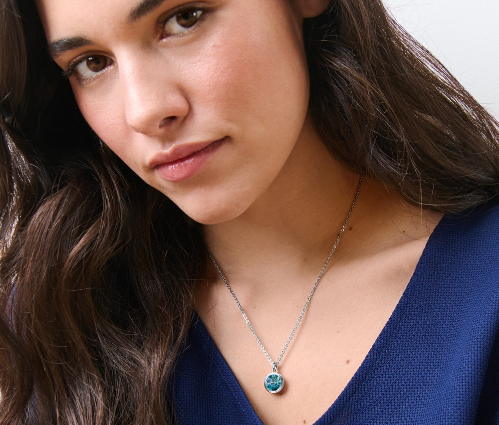 Bir kadın, Mavi Uçlu Kolye takıyor.