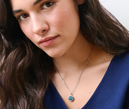 Bir kadın, Mavi Uçlu Kolye takıyor.