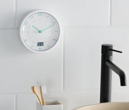 Banyo duvar saati, lavabo ve diş fırçası tutucunun yanında 11:22'yi gösteriyor.