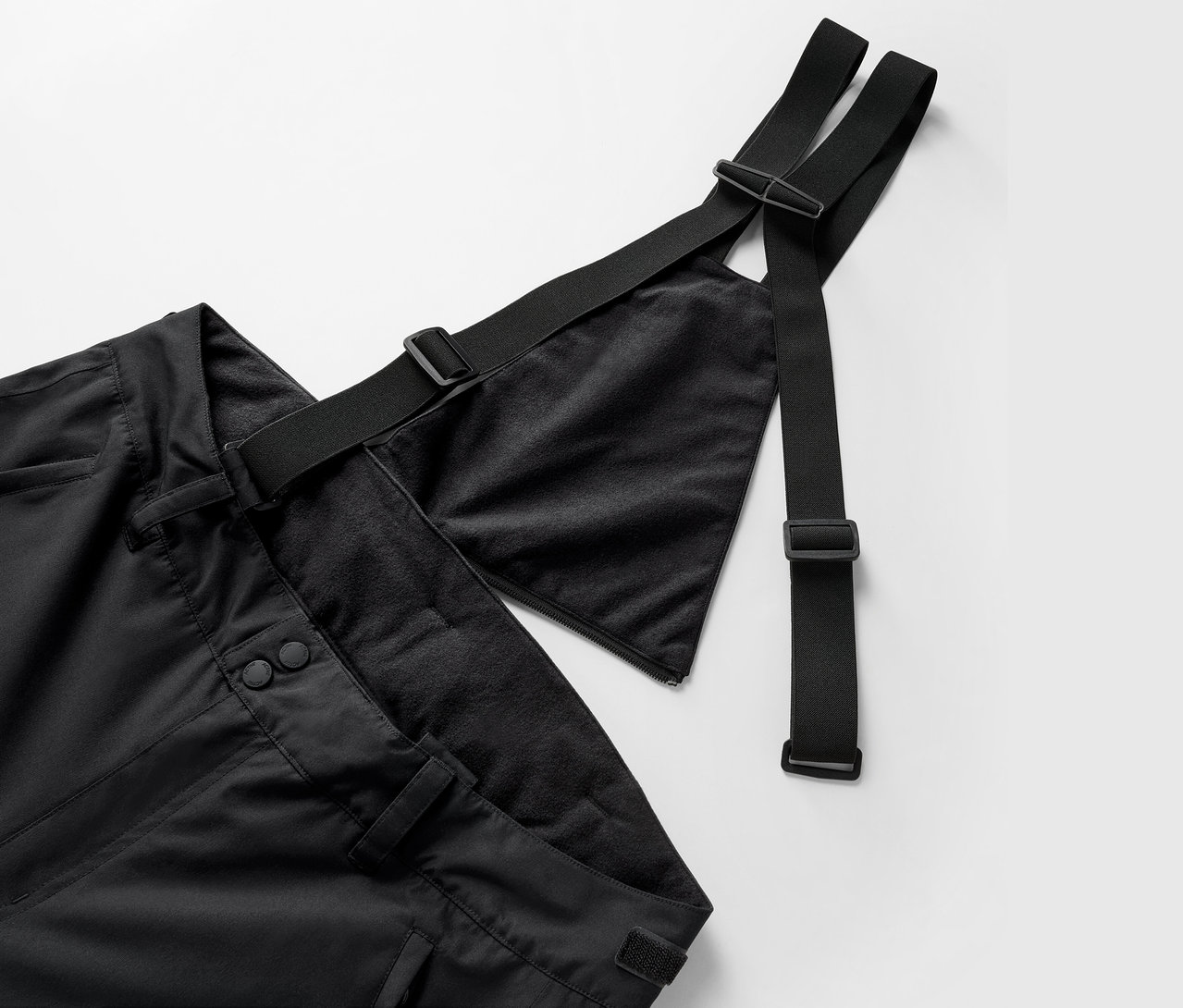Askılı ve ayarlanabilir kayışları olan siyah bir pantolonun yakın çekimi.