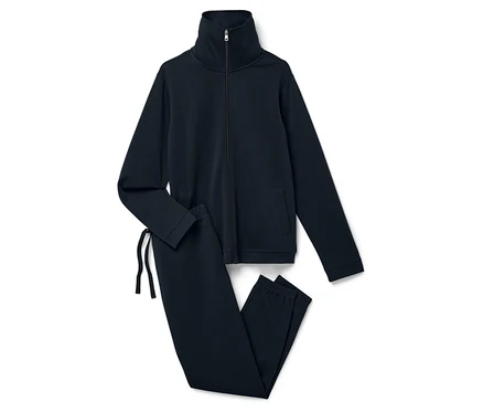 Beyaz bir arka plan üzerinde lacivert bir fermuarlı sweatshirt ve pantolondan oluşan eşofman takımı duruyor.