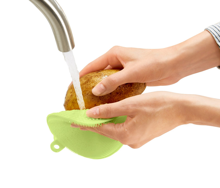 Kadın patatesi akan suyun altında 2 Adet Silikon Bulaşık Pedi ile yıkıyor.