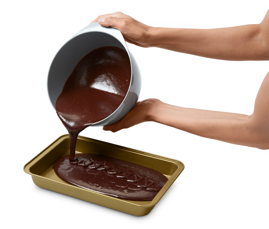 Kahverengi hamur bir kaseden brownie pişirme kalıbına dökülüyor.