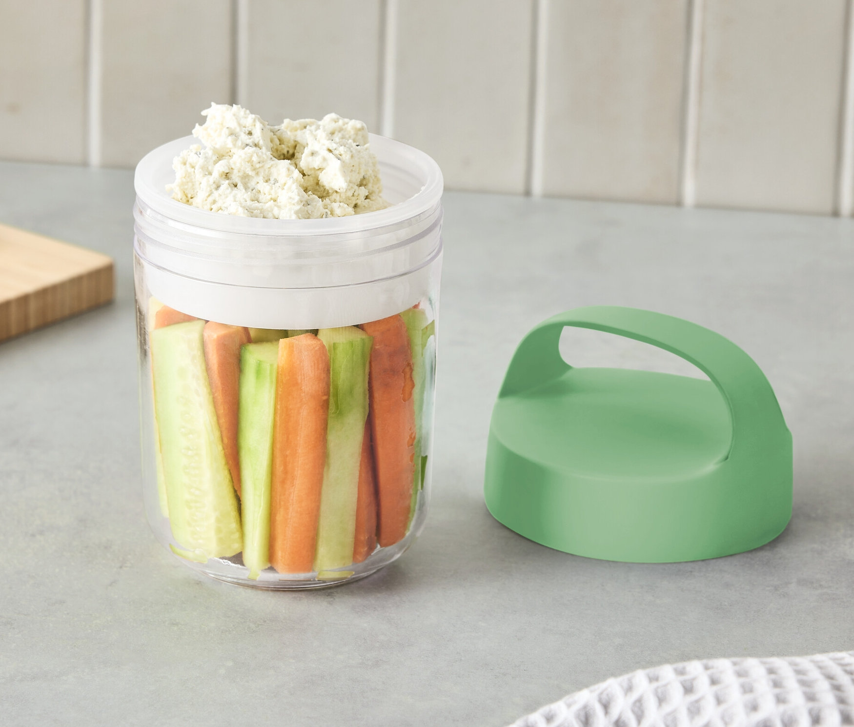 Doğranmış sebze ve sos ile dolu, kulplu küçük bir kap.