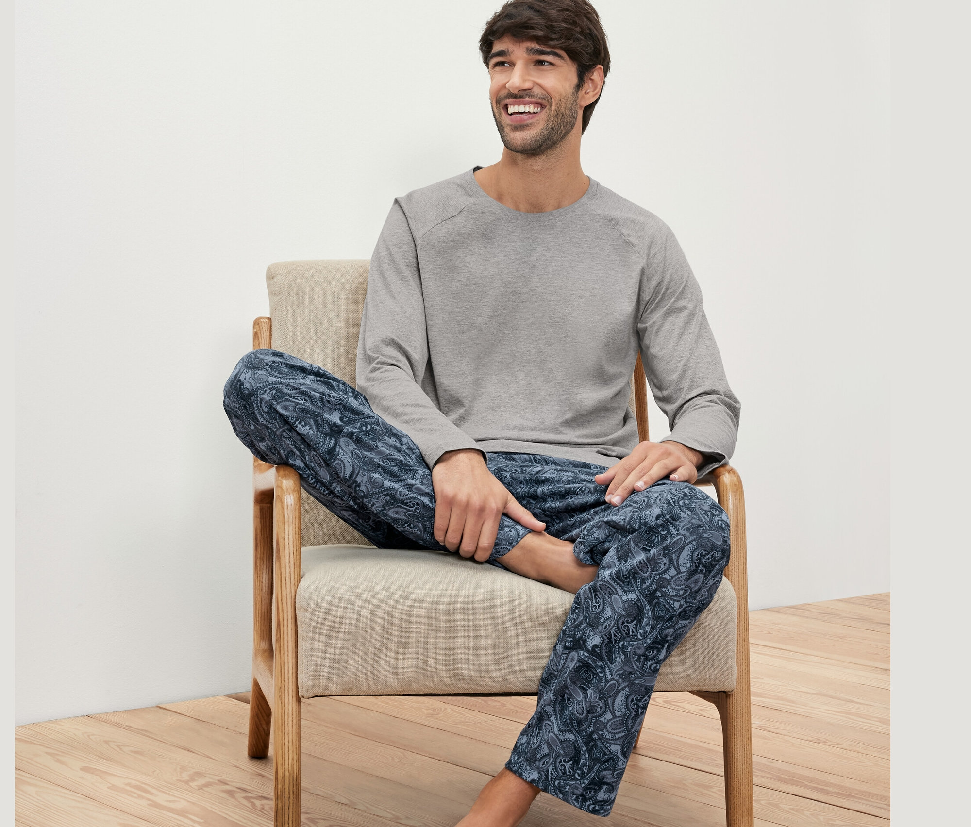 Adam sandalyede oturuyor ve Pijama Seti giyiyor.