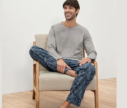 Adam sandalyede oturuyor ve Pijama Seti giyiyor.
